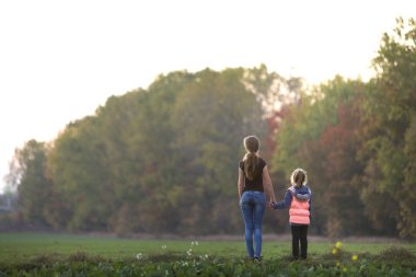 Arkadan görünüşü arasında genç ince çekici anne ve çocuk kız
