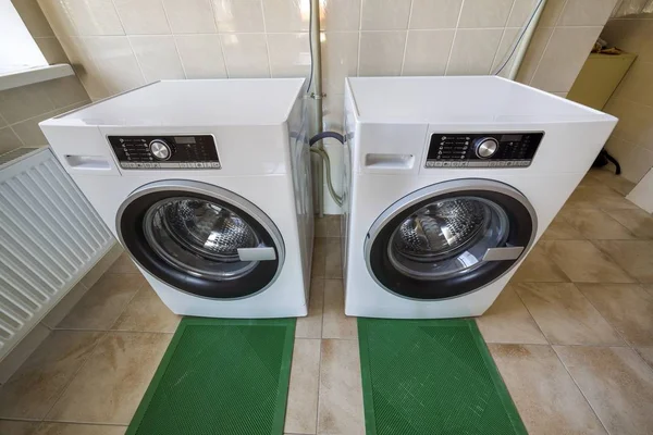 Современные новые промышленные стиральные машины в чистой кафельной ванной комнате o — стоковое фото