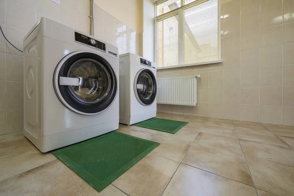 Modernas lavadoras industriales nuevas en baño de azulejos limpios o — Foto de Stock