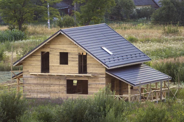 Vue aérienne de la nouvelle maison traditionnelle écologique en bois chalet de matériaux naturels avec plancher grenier, véranda, balcon et toit en bardeaux en construction en zone rurale . — Photo