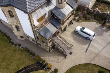 Yeni pahalı beyaz araba ile Asfaltlı iyi tutulan avluya Park