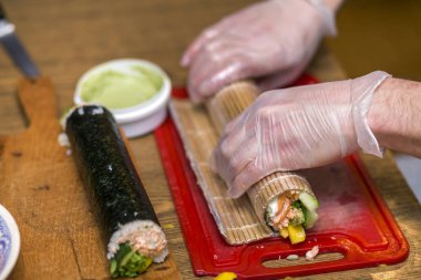 Suşi ve rulo yapma işlemi. Adam Şef Close-Up pr eller