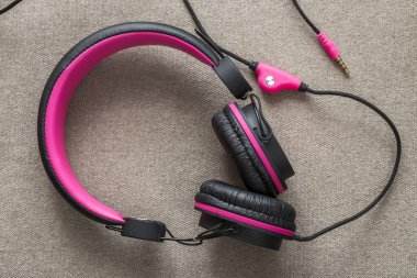 Headphone black and pink isolated on light cloth flat copy space