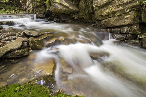 Rychle tekoucí proud řeky s hladkým hedvábným vody padající z b — Stock fotografie