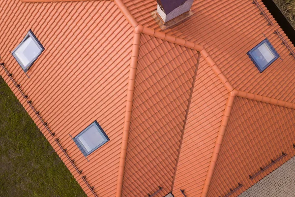Bovenaanzicht van huis metalen Shingle dak, bakstenen schoorstenen en kleine plastic zolderramen. Dakbedekking, reparatie-en renovatiewerkzaamheden. — Stockfoto