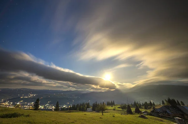 Summer night mountain panorama. Green grassy mountain clearing,