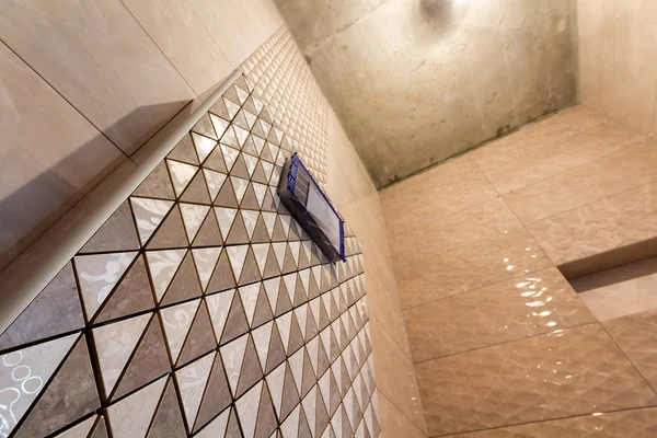 Reconstrucción inacabada de baño o inodoro con azulejos de cerámica mosaico geométrico beige claro instalado en las paredes, lugar para el baño y el baño. Ángulo bajo, vista inferior . — Foto de Stock