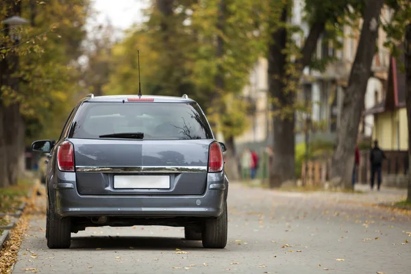 Grijze glimmende auto geparkeerd in rustige wijk op asfaltweg op wazig b — Stockfoto