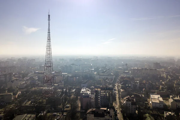 Aerial view of modern city urban foggy landscape with tall telev