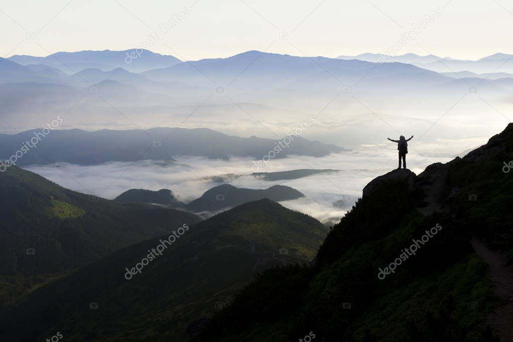Wide mountain panorama. Small silhouette of tourist with backpac