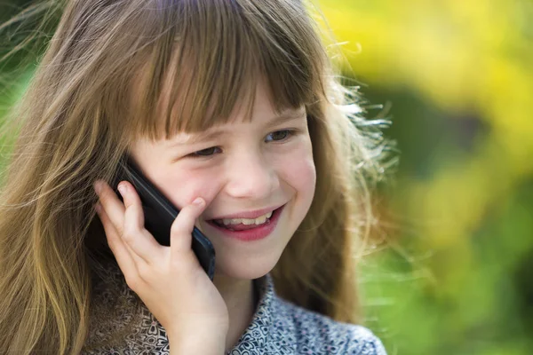 Niña linda joven hablando en el teléfono celular al aire libre. Niños y niñas — Foto de Stock