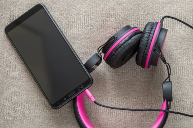 Cep telefonu üzerinde hafif kumaş düz co izole kulaklık bağlı