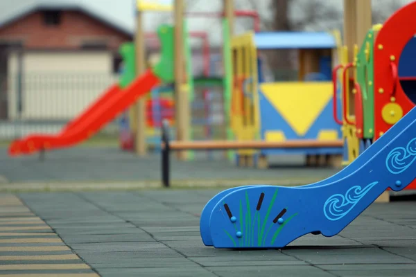 Bright färgglada bilder på dagis lekplats med mjuka gummigolv på ljusa soliga sommardag. Barnaktiviteter och rekreation utomhus. — Stockfoto
