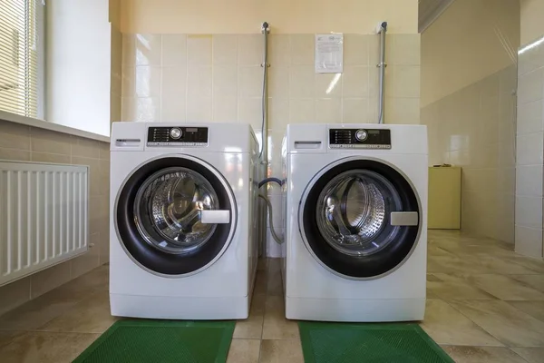 Modernas novas máquinas de lavar roupa industrial em banheiro de azulejos limpos o — Fotografia de Stock