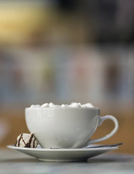 Caneca de café com marshmallows em placa de porcelana em co turvo — Fotografia de Stock