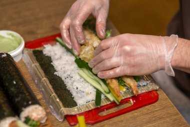 Suşi ve rulo yapma işlemi. Adam Şef Close-Up pr eller