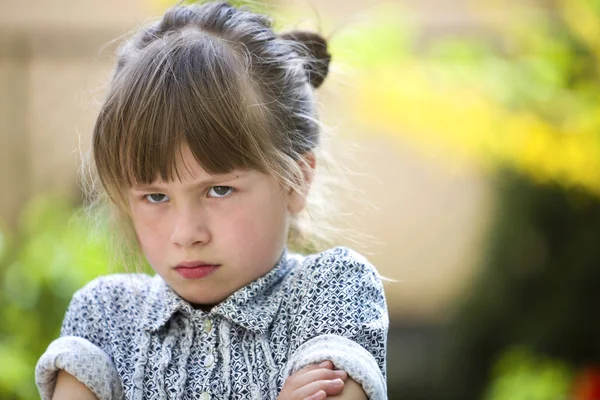 かなり面白い気分の若い女の子の屋外感怒りとぼやけた夏の緑の背景に不満。子供のタントラムの概念. — ストック写真