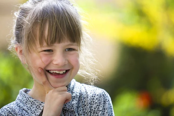 Schattig mooi kind meisje met grijze ogen en eerlijke haren glimlachend in c — Stockfoto