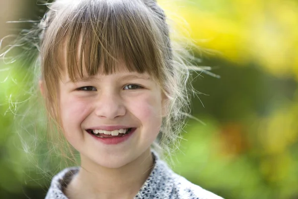 Schattig mooi kind meisje met grijze ogen en eerlijke haren glimlachend in c — Stockfoto