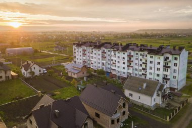 Gelişmekte olan şehir Peyzaj üst görünümü. Sunrise arka planda pembe gökyüzünde daire bina ve banliyö ev çatıları. Drone fotoğrafçılığı.