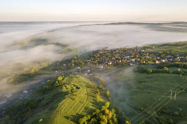 Vista superior de la niebla verde colina cubierta de hierba, techos de la casa de pueblo en vall — Foto de Stock