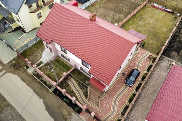 Εναέρια κορυφή θέα του σπιτιού με βότσαλα στέγη και καμινάδα τούβλο σε ήσυχη γειτονιά, μαύρο αυτοκίνητο σε πλακόστρωτη αυλή. Καλά διατηρημένο έννοια της ιδιοκτησίας. — Φωτογραφία Αρχείου
