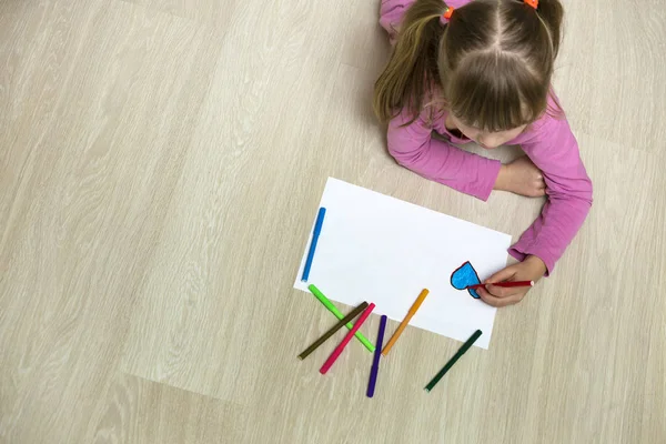 Dziecko dziewczyna rysunek z kolorowych ołówków kredki serce na białym — Zdjęcie stockowe