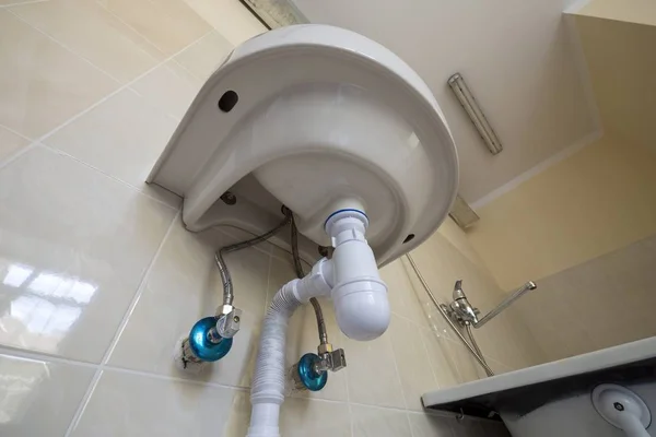 Ba üzerinde kanalizasyon bağlı yeni beyaz lavabo lavabo alt görünümü — Stok fotoğraf