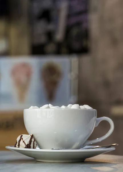 Caneca de café com marshmallows em placa de porcelana em co turvo — Fotografia de Stock