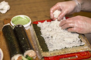Suşi ve rulo yapma işlemi. Adam Şef Close-Up pr eller