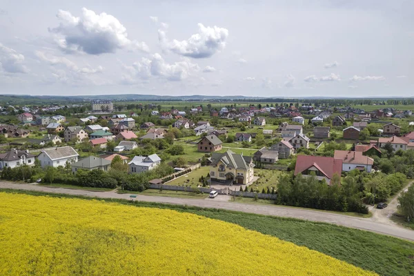 Vista aérea de la carretera terrestre en campos verdes con colza en flor — Foto de Stock