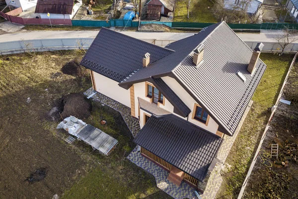 Aerial top view of building steep shingle roof, brick chimneys a