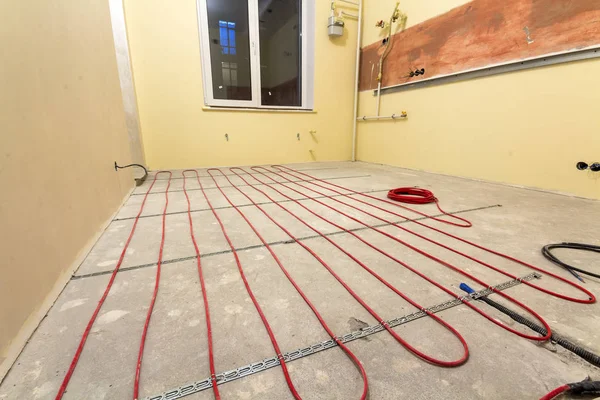 Riscaldamento cavo elettrico rosso installazione sul pavimento di cemento i — Foto Stock