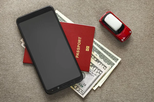Svart mobiltelefon, pengar amerikanska dollarsedlar räkningar, passet förf lyttning — Stockfoto