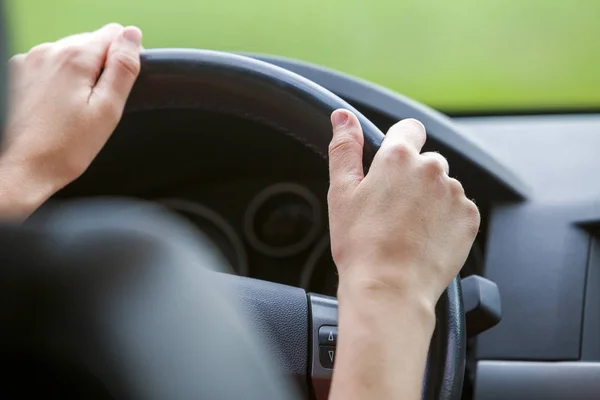 Mujer manos en el volante conduciendo un coche . — Foto de Stock