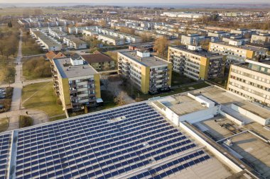 Şehir peyzaj arka planda yenilenebilir temiz enerji üreten ticari çatı mavi parlak güneş fotoğraf voltaik paneller sisteminin havadan görünümü.