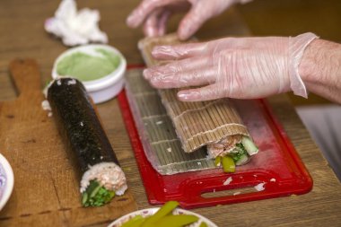 Suşi ve rulo yapma işlemi. Adam Şef Close-Up pr eller