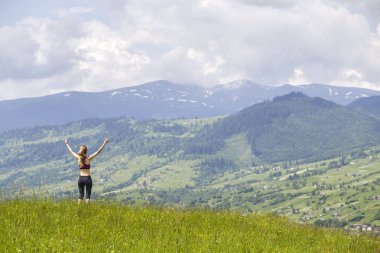 Beau arka planda yükseltilmiş silah ile ince genç kadın
