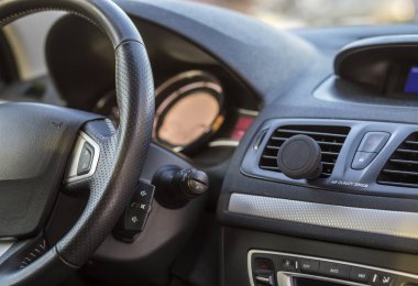 Lüks araba iç. Pano ve direksiyon siyah gri renkte. Ulaşım, tasarım, modern teknoloji kavramı.