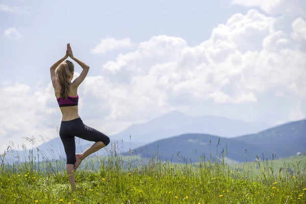 Attraktive schlanke junge Frau macht Yoga-Übungen im Freien auf Bac — Stockfoto