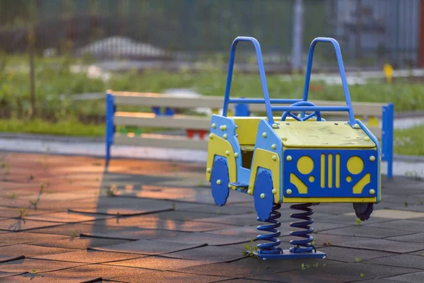 Parco giochi per bambini con auto giocattolo luminoso in primavera. Bambini. — Foto Stock