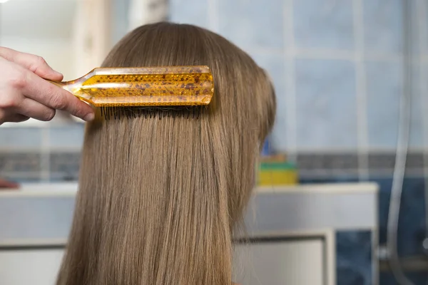 Mère main avec brosse peignage longs cheveux blonds de mignon enfant fille — Photo