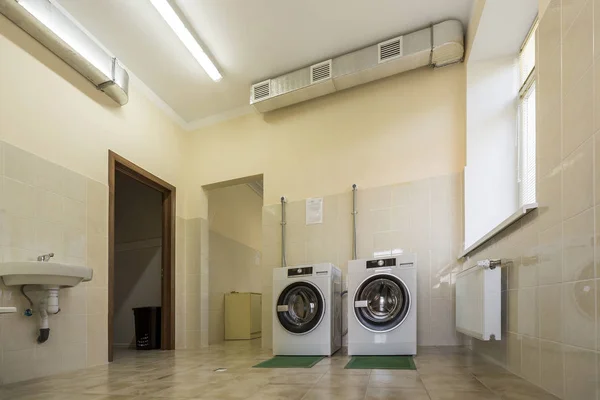 Современные новые промышленные стиральные машины на резиновых изоляционных ковриках — стоковое фото
