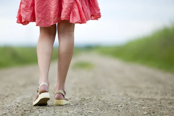 ग्राउंड दोन चालत लाल ड्रेस पाय मध्ये तरुण स्त्री मागे दृश्य — स्टॉक फोटो, इमेज