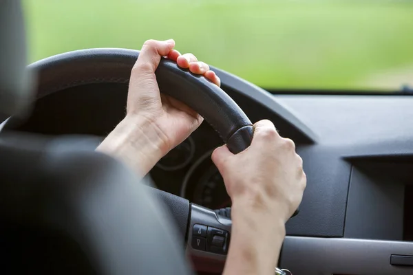 Mujer manos en el volante conduciendo un coche . — Foto de Stock