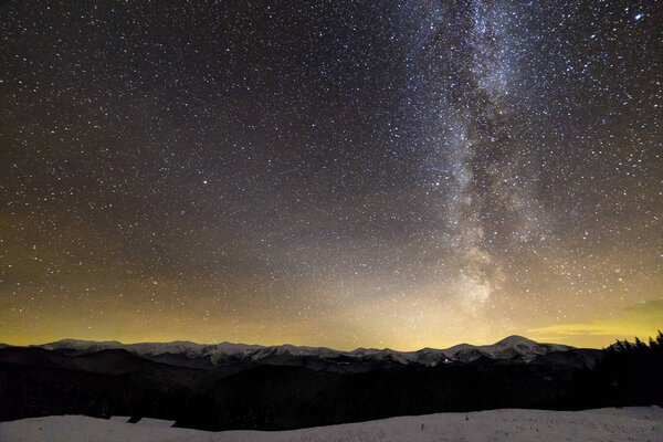 Winter mountains night landscape panorama. Milky Way bright cons