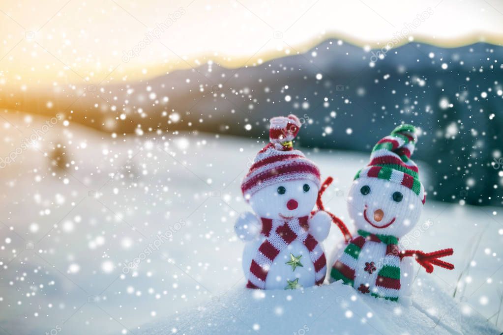 Two small funny toys baby snowman in knitted hats and scarves in