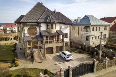 Yeni pahalı beyaz araba ile Asfaltlı iyi tutulan avluya Park