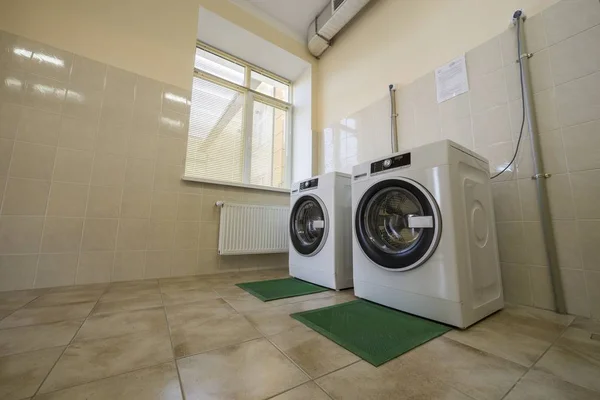 Modern new industrial washing machines on rubber insulation mats — Stock Photo, Image