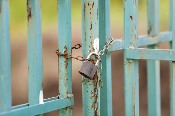 Cerca enferrujada velha ou portão com cadeado acorrentado . — Fotografia de Stock